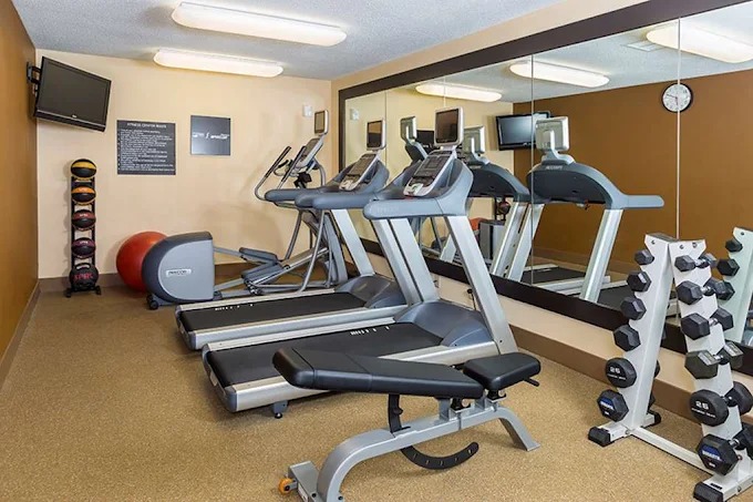 Fitness center with treadmills, dumbbells, and training equipment